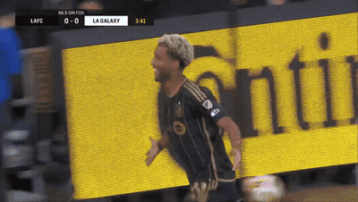 A Soccer Player Celebrates A Goal In Front Of A La Galaxy Banner GIF