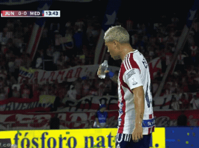 A Soccer Player Holds A Bottle Of Water In Front Of A Sign That Says Fosforo Natural GIF