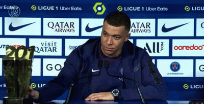 A Soccer Player Holds A Trophy In Front Of A Qatar Airways Advertisement GIF