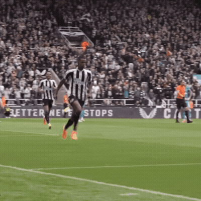 A Soccer Player In A Black And White Striped Jersey Is Running On The Field GIF