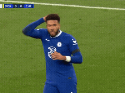 A Soccer Player In A Blue Jersey Is Standing On A Soccer Field With His Hand On His Head . GIF
