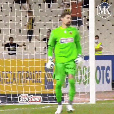 A Soccer Player In A Green Uniform Is Standing In Front Of A Net GIF