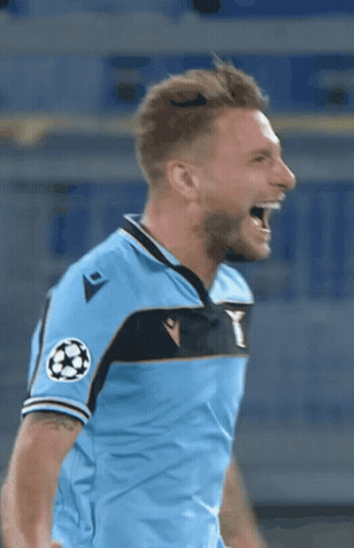 A Soccer Player In A Light Blue Shirt Is Screaming With His Mouth Open . GIF