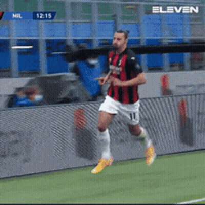 A Soccer Player In A Red And Black Jersey Is Running On A Field GIF