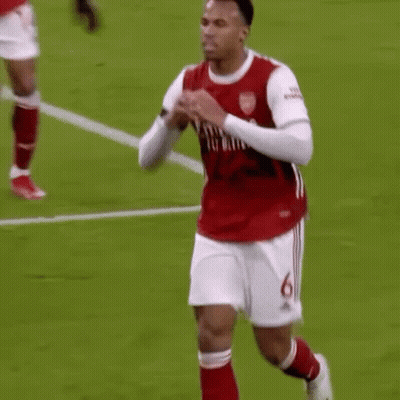 A Soccer Player In A Red Shirt And White Shorts Is Running On A Field . GIF