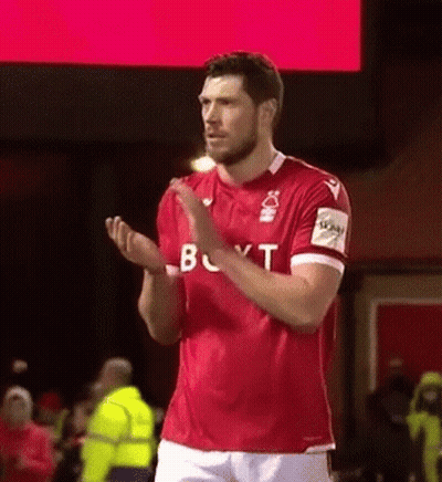 A Soccer Player In A Red Shirt Is Applauding The Crowd . GIF
