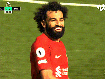 A Soccer Player In A Red Shirt Is Looking Down At Something GIF