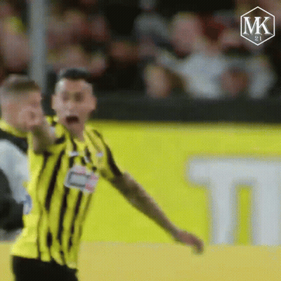 A Soccer Player In A Yellow And Black Striped Shirt Is Screaming On The Field . GIF