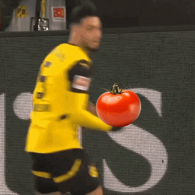 A Soccer Player In A Yellow Jersey Holds A Tomato GIF