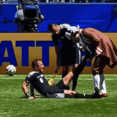 A Soccer Player Is Being Helped On The Field By A Man In A Pirate Outfit GIF