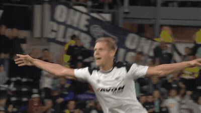 A Soccer Player Is Celebrating A Goal In Front Of A Banner That Says One GIF