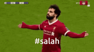 A Soccer Player Is Celebrating A Goal With A # Salah Hashtag . GIF