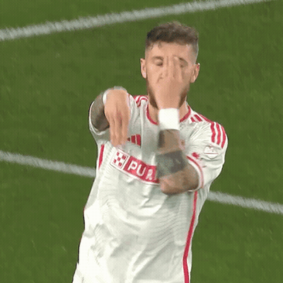 A Soccer Player Is Covering His Face With His Hands While Wearing A White Jersey With Red Stripes GIF