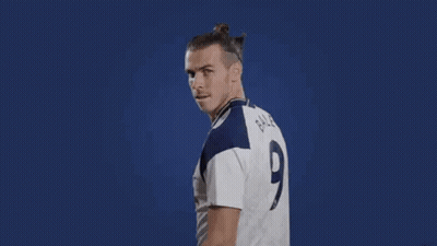 A Soccer Player Is Flexing His Muscles While Wearing A White Jersey With A Number 9 On It . GIF