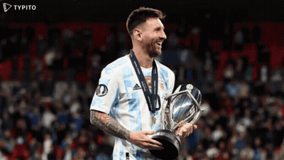 A Soccer Player Is Holding A Trophy And Smiling With A Typito Logo In The Background GIF