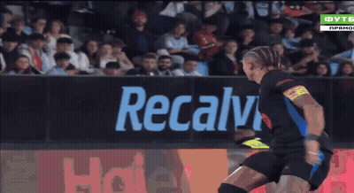 A Soccer Player Is Kicking A Ball In Front Of A Haier Sign GIF