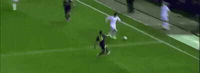 A Soccer Player Is Kicking A Ball Into The Goal While A Crowd Watches . GIF