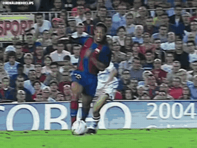 A Soccer Player Is Kicking A Soccer Ball In Front Of A Crowd Of People . GIF