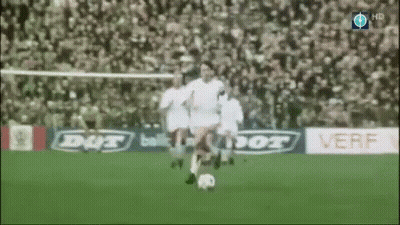 A Soccer Player Is Kicking A Soccer Ball On A Field With Ads For Dut And Verf In The Background GIF