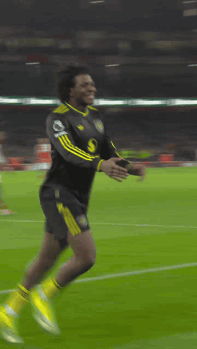 A Soccer Player Is Kneeling Down On The Field With A Banner Behind Him That Says ' Heineken ' GIF
