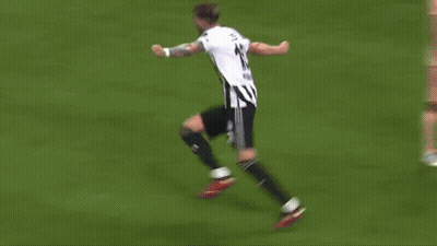 A Soccer Player Is Kneeling Down On The Field With His Arms In The Air . GIF