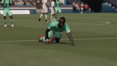 A Soccer Player Is Kneeling Down On The Field With His Arms In The Air While Another Player Kicks Him . GIF