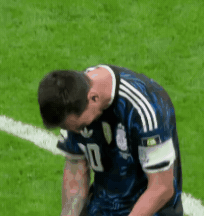 A Soccer Player Is Kneeling Down On The Field With His Head Down . GIF