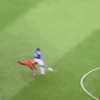 A Soccer Player Is Kneeling On The Field While Another Player Stands Behind Him . GIF