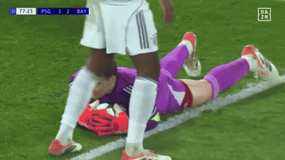 A Soccer Player Is Laying On The Field While Another Player Kicks Him . GIF