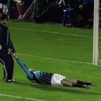 A Soccer Player Is Laying On The Field While Being Pulled By Another Player GIF