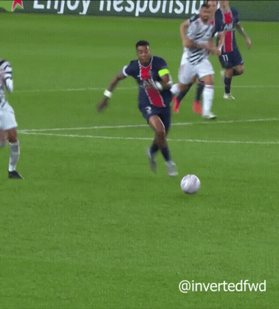 A Soccer Player Is Laying On The Ground While Another Player Is Jumping In The Air GIF