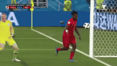 A Soccer Player Is Running Towards The Goal While A Goalie Stands Behind Him GIF