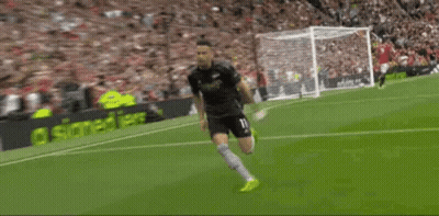A Soccer Player Is Saluting The Crowd On The Field . GIF