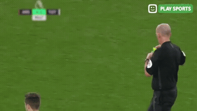 A Soccer Player Is Standing Next To A Referee On A Field . GIF