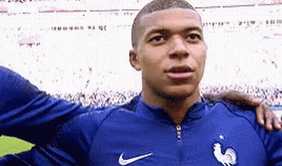 A Soccer Player Is Standing On A Field With His Arm Around Another Player . GIF