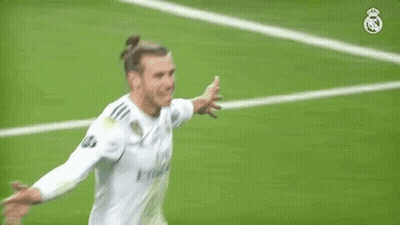 A Soccer Player Is Standing On A Field With His Arms Outstretched And Smiling . GIF