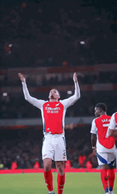 A Soccer Player Is Standing On A Field With His Arms Outstretched And Smiling . GIF