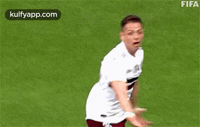 A Soccer Player Is Standing On A Field With His Arms Outstretched And Smiling . GIF