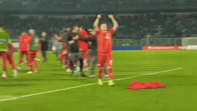 A Soccer Player Is Standing On The Field With His Hands In The Air . GIF