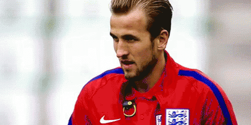 A Soccer Player Is Wearing A Red Shirt With A Blue Stripe On The Sleeves . GIF