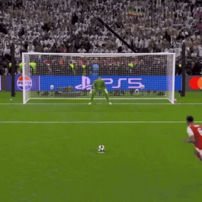 a soccer player kicks a ball in front of a ps5 banner