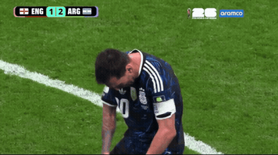 A Soccer Player Kneeling Down On The Field With A Scoreboard Behind Him That Says Aramco GIF