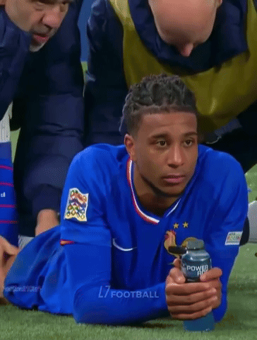 A Soccer Player Laying On The Grass With A Can Of Powerade In His Hand GIF