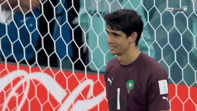 A Soccer Player Stands In Front Of A Coca Cola Advertisement GIF