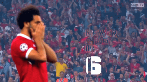 A Soccer Player Stands In Front Of A Crowd With A Sign That Says Never Give Up GIF