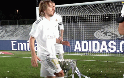 A Soccer Player Stands In Front Of A Sign That Says Adidas On It GIF