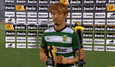 A Soccer Player Stands In Front Of A Wall With Bwin Advertisements GIF