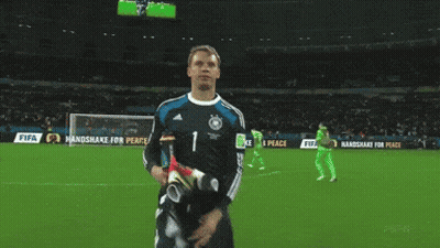 A Soccer Player Stands On A Field With A Sign That Says Handshake For Peace GIF