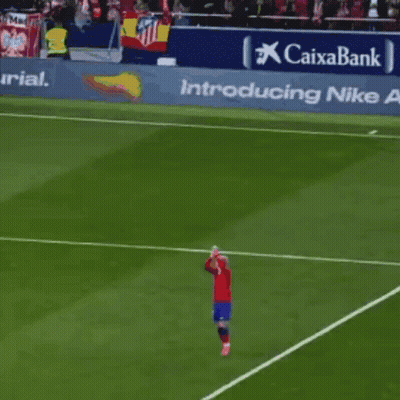 A Soccer Player Stands On The Field In Front Of A Banner That Says Caixabank GIF
