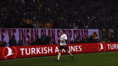 A Soccer Player Stands On The Field In Front Of A Banner That Says Enjoy Responsibly GIF